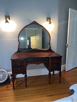 Front view showing full vanity with attached mirror beneath wall sconces