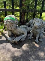 Overall photo showing the girl statue lying on stomach reading a book with dragonfly details and the puppy statue sitting beside her.