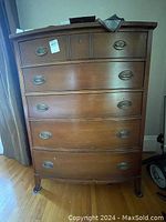 Front view of full highboy dresser showing six drawers and bracket feet