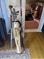 Full view of golf bag with vintage junior right-handed golf clubs, Easton softball bat, and hockey stick.