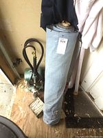 Photo of propane weed torch with brass valve and black hose next to rolled material and clothing.