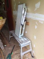 Pair of aluminum folding work stands shown folded and set on the floor and on another work stand for scale and detail.