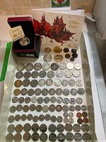 Overview of all coins including boxed silver coin, two mint set booklets and loose coins