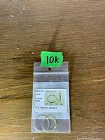 Photo of two 10k gold keeper earrings inside a small clear plastic bag with labeling from Mayhew Jewelers.