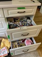Open drawer showing batteries including Duracell and Energizer, small hand tools, timers, glue sticks, and mouse traps in a white kitchen drawer.