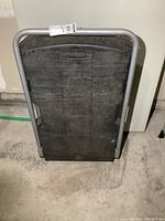 Rubbermaid moving cart folded upright showing black platform and metal handle.