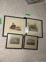 All four framed prints displayed on carpet, showing two elephant prints and two vintage photos.