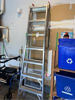 Full view of aluminum extension ladder in garage, showing height and general condition.