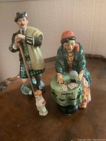 Photo showing The Laird figurine in Scottish attire and the Fortune Teller with the little boy figurine nearby.