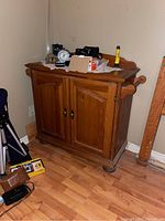 Front view of pine wash stand showing double doors, inner shelf behind doors, and flat top surface with items on top (not included).