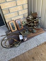 Photo of all items grouped together including the scale, candle holders on wood plaques, metal horns, and brass leaf