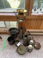 Wide view of lot showing brass plant stand, metal vases, bed warmer, salt and pepper shakers, and decorative metal horns.