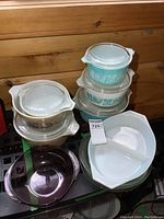 Overall display of six bowls on metal shelf against wood wall