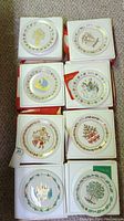Top view showing all eight Spode Christmas plates from 1970-1977 in their boxes, stacked in two columns of four.