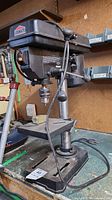 Full view of the Jobmate drill press showing the motor housing, spindle, and base.