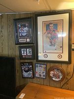 Overall view of six framed hockey prints and décor on wood-paneled wall