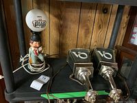 Full view of pub desk lamp and two Seagrams VO wall lights together on a shelf.