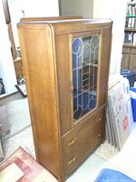 Full view of vintage wooden china cabinet with glass door and two drawers