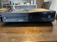 Side view of Xbox One console showing disk slot and power button.