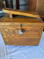 Closed wooden shoe shine box with hinged lid on top