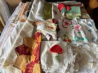 Full view of assorted folded linens including various napkins, runners, and doilies in different colors and patterns