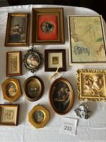 Eleven assorted vintage and antique framed prints and artworks displayed on a table showing various frames and subjects