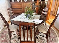 Front view of round table with lace topper, glass protector, and all six chairs