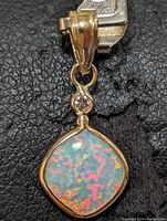 Front view of pendant showing opal’s play-of-color and diamond accent