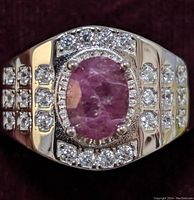 Front view of the sterling silver ring showing the oval ruby and surrounding cubic zirconia stones