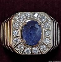 Front view of the sterling silver ring with oval sapphire center and cubic zirconia halo stones