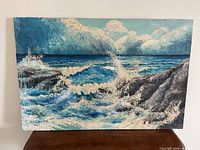 Full front view of seascape oil painting with waves and rocks