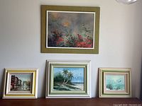 Four framed art pieces displayed together on a wall, showcasing different themes and frame styles.