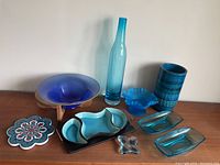 Items arranged on a wooden surface showing all the glassware and decorative items in the lot