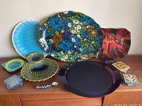 Wide front view of all platters and coasters together on wood furniture surface.