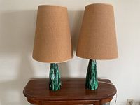 Two lamps side by side on wooden table, unlit