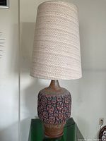 Full view of lamp with shade on green acrylic stand