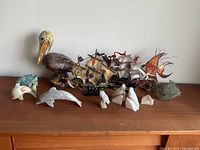 Full display of all items including pelican, model ships, and stone figures on wooden dresser