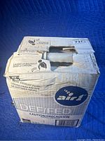 Box of Air1 DEF/FED diesel exhaust fluid, showing front and side with product information and branding