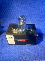 Front view of the Delta bathroom faucet on display base showing the chrome finish and single lever handle.