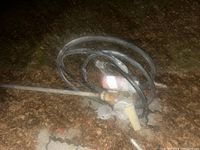 Photo showing side view of diesel fuel pump on ground, with attached black hose coiled and inline filter visible.