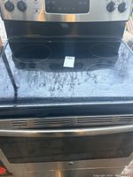 Front view of GE self-cleaning flat top electric stove showing cooktop, oven door, control panel and knobs.