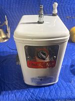 Front and top views of Quick & Hot water heater unit showing temperature dial and water connection fittings.