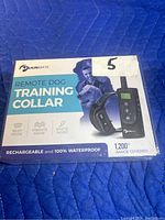 Box front showing BrainMate remote dog training collar packaging with product features: beep mode, vibrate mode, static mode, rechargeable, 100% waterproof, and 1200 feet range.
