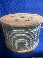 Full side view of wooden spool wound with interlocked steel-armored cable