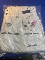 Photo of snow pants sealed in original packaging showing brand, size, and origin.