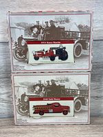 Photo of the fronts of the two boxed model cars showing 1914 Knox-Martin fire truck and 1948 Task Master bus