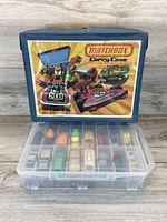 Blue plastic Lesney Matchbox carrying case with colorful graphic showing ability to hold 28 models.