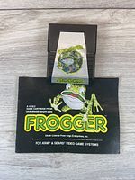 Front view of Frogger Atari game cartridge with original cover/artwork displaying frog graphic and logo.