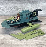 Photo of GI Joe Dreadnok Monkeywrench figure seated in the vehicle with attached green serrated weapon parts.