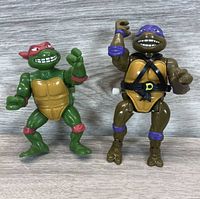 Front view of Raphael and Donatello Teenage Mutant Ninja Turtles windup action figures showing detailed faces and front body features.